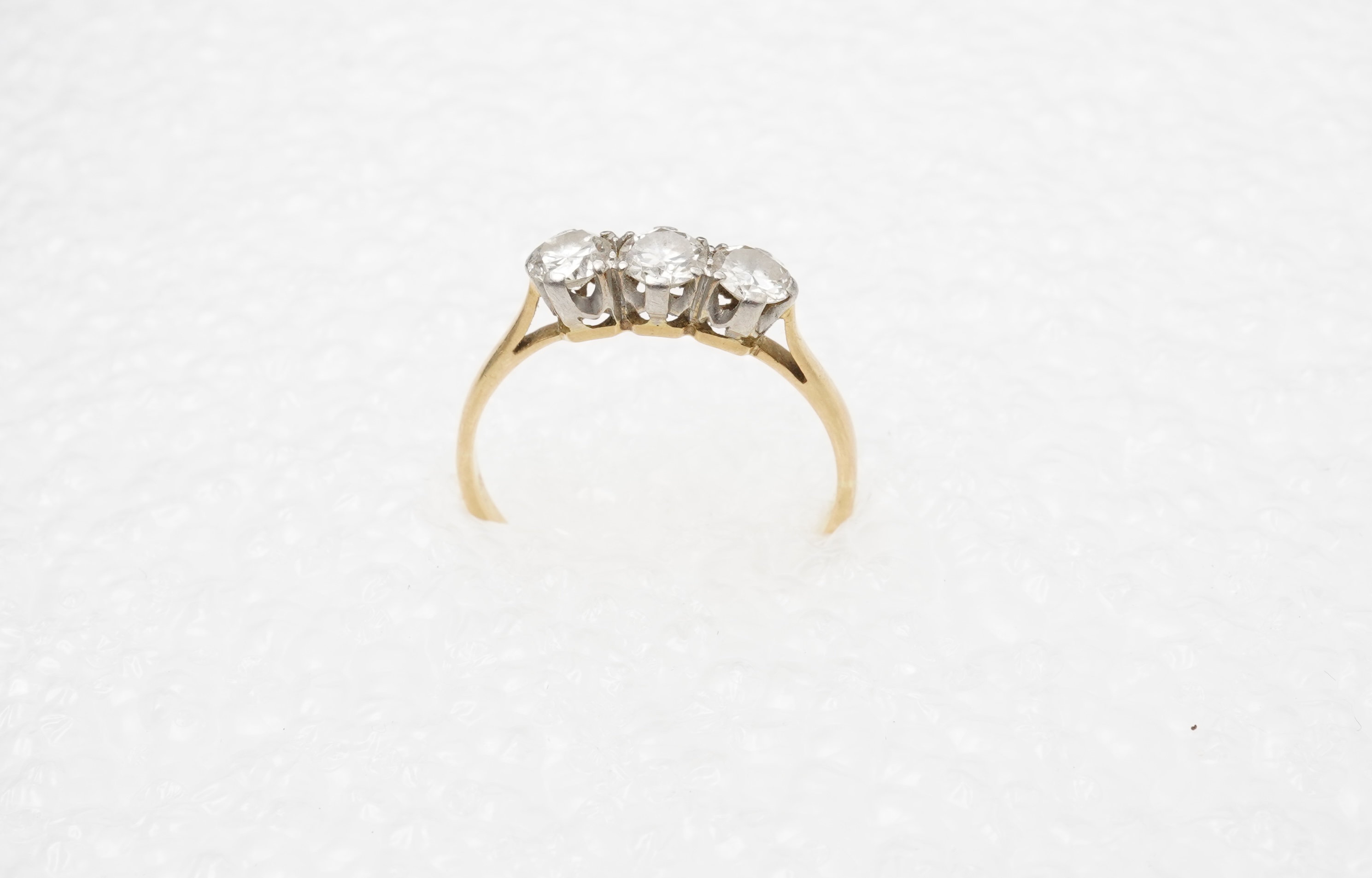 A diamond three-stone ring, set with three circular-cut diamonds totalling approximately 0.50 carats, mounted in gold, size O, stamped 18CT, gross weight approximately 2 grams